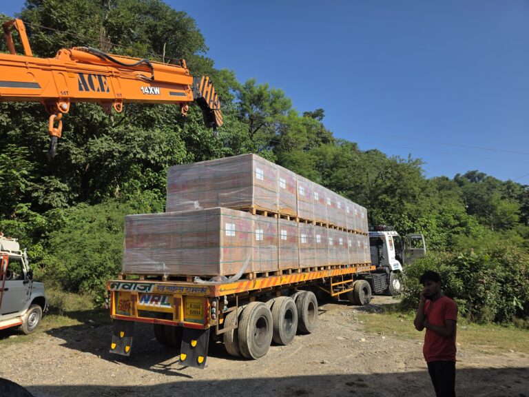 Crane beside a truck delivering packaged equipment to the site.